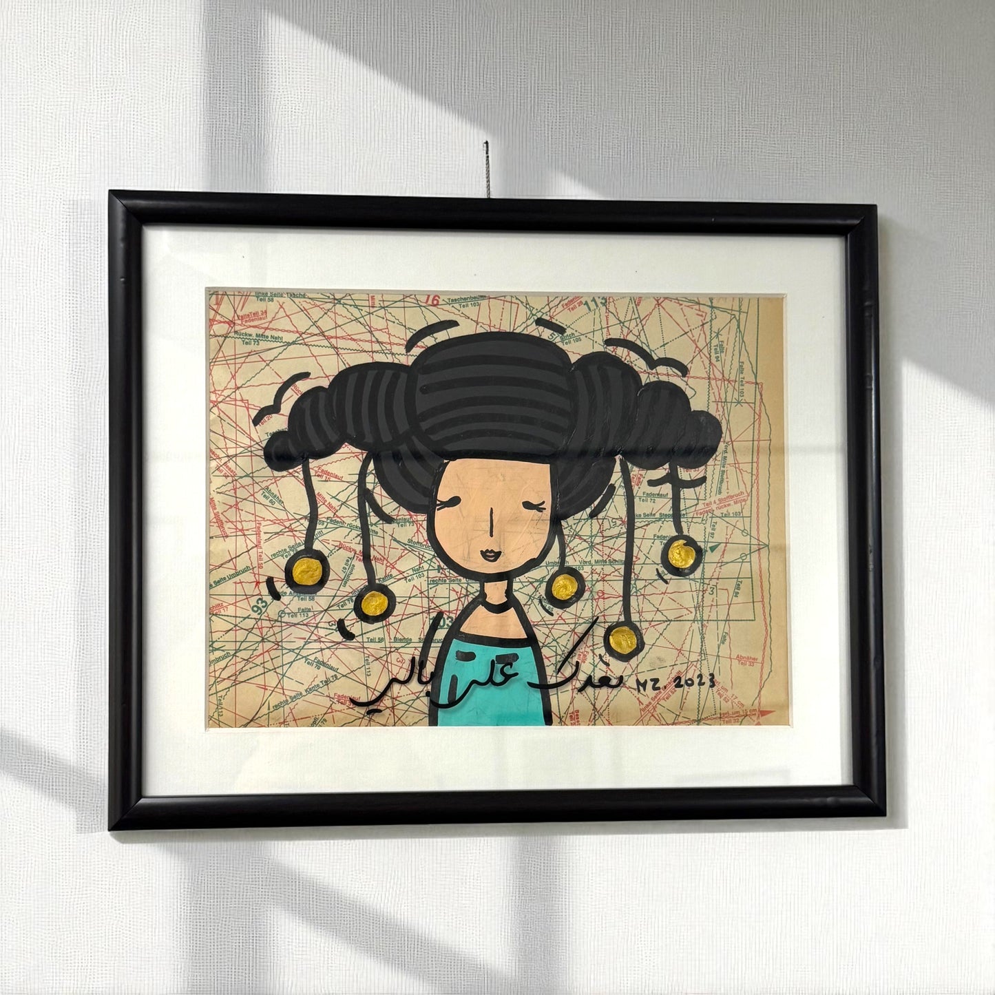 Framed artwork of a stylized illustration of a woman with braided hair and yellow beads on a map background.