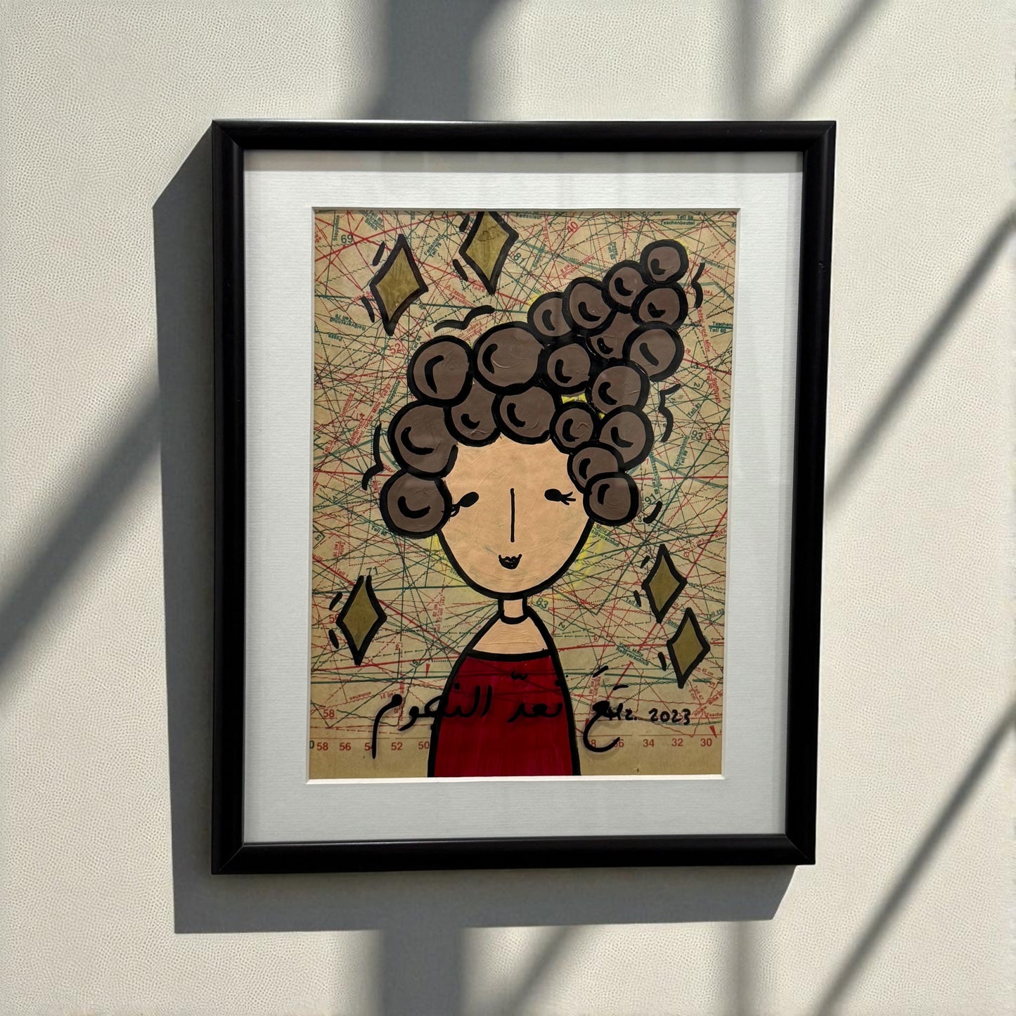 Framed artwork of a stylized face with brown hair on a textured background