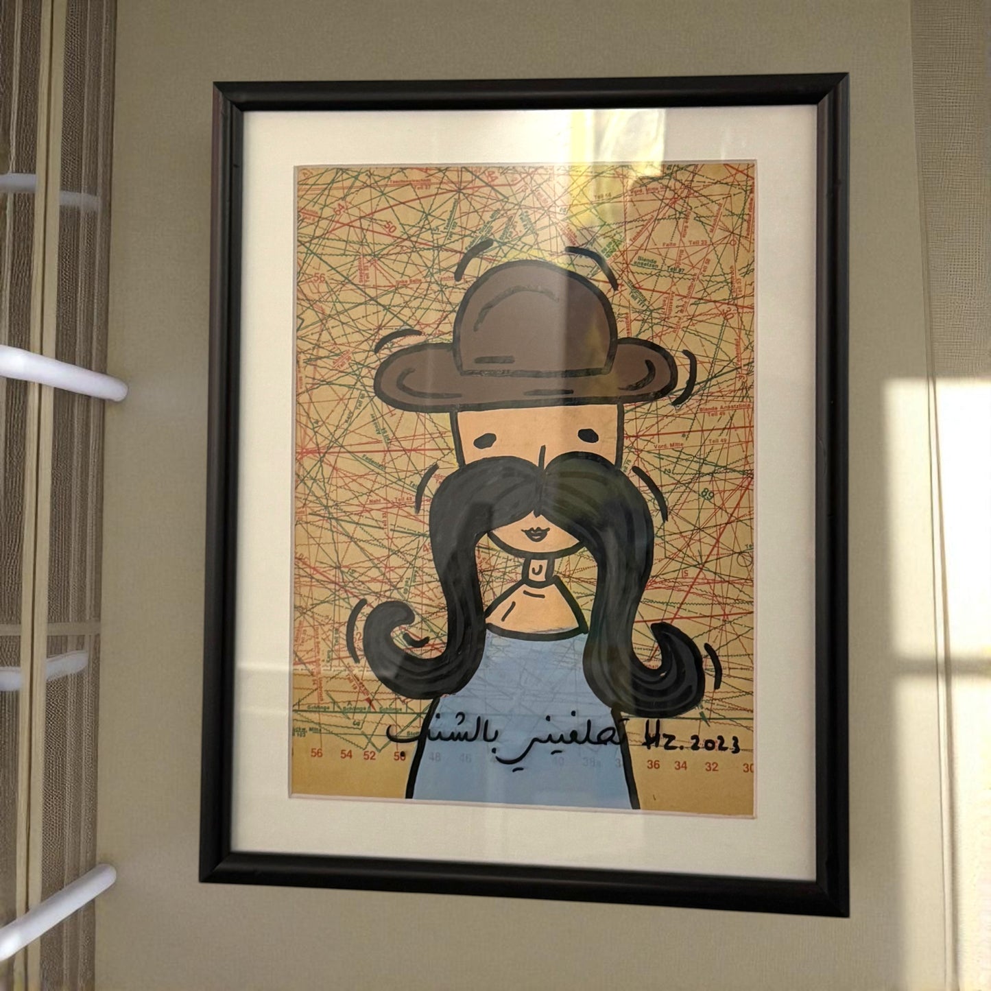 Framed artwork of a person with a hat and long beard on a map background