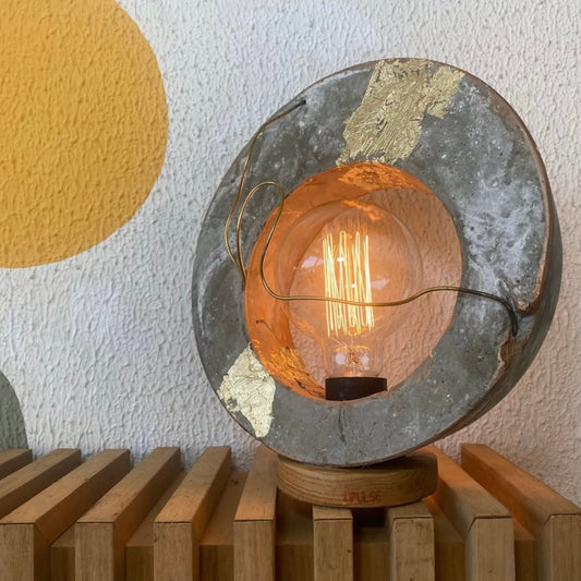 A lamp with a circular metallic structure and a bulbous light bulb