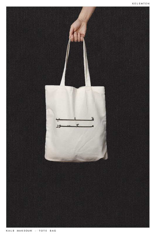 A white tote bag with a graphic print in the center "kaleb maksour"